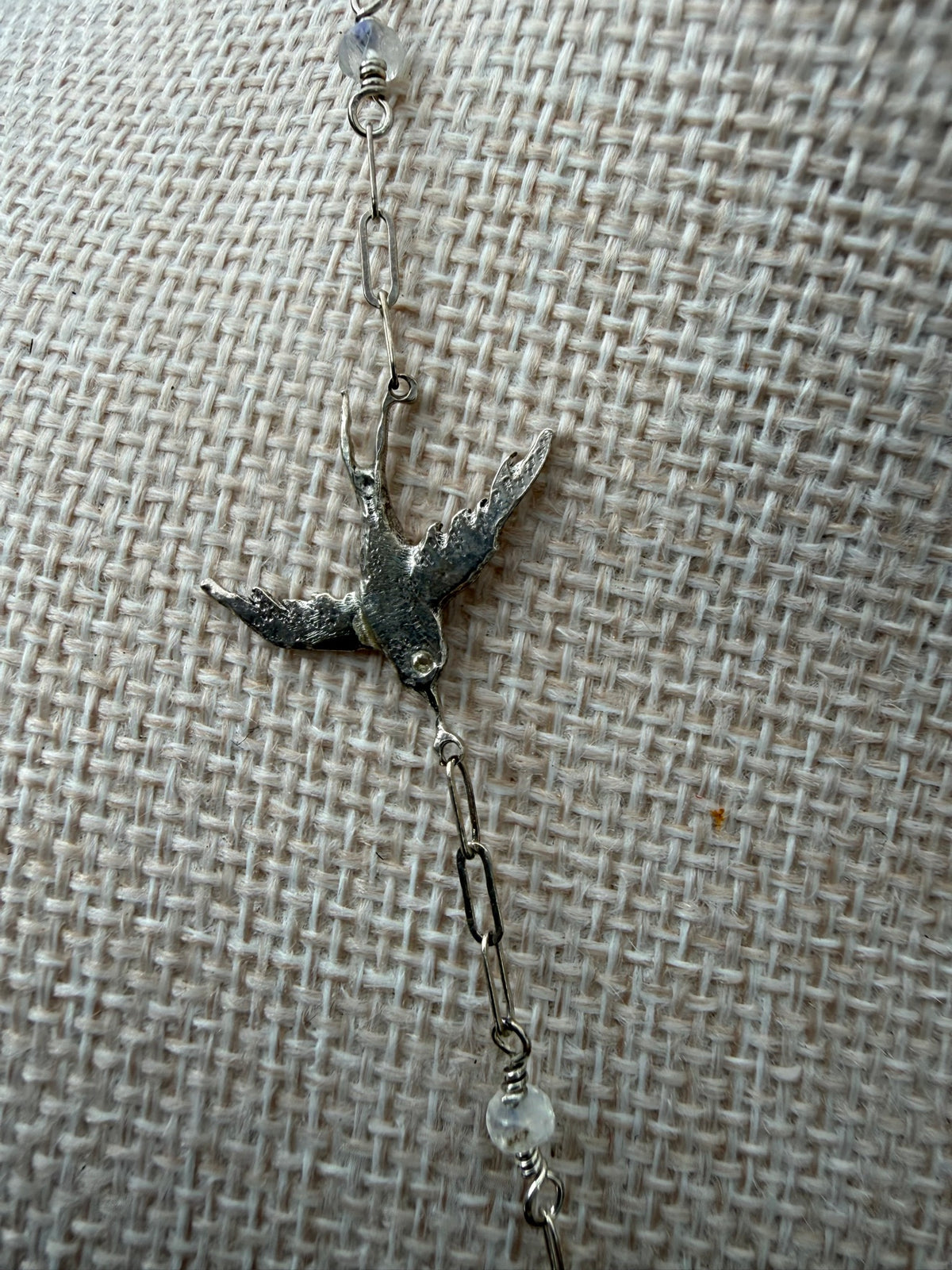 Swallow detail — sterling silver swallow in flight on a paperclip chain with moonstone beads