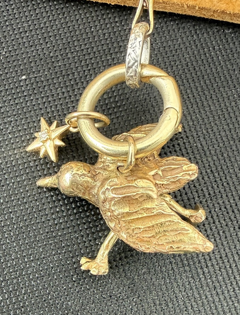 14k gold articulated piping plover hanging from the convertible chain clasp; star charm sold separately