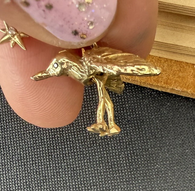 Side view — solid cast 14k gold piping plover with a black lab-grown diamond eye