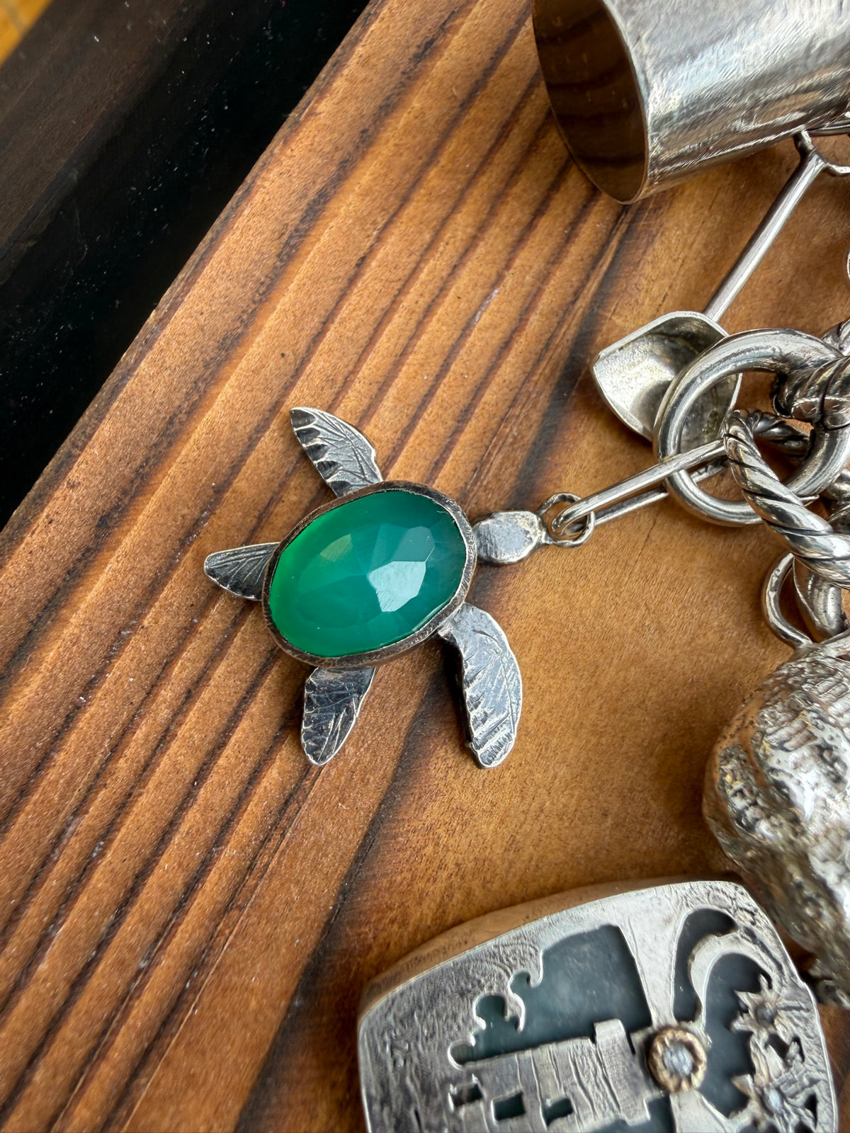 Articulated turtle charm with a faceted green onyx shell in sterling silver