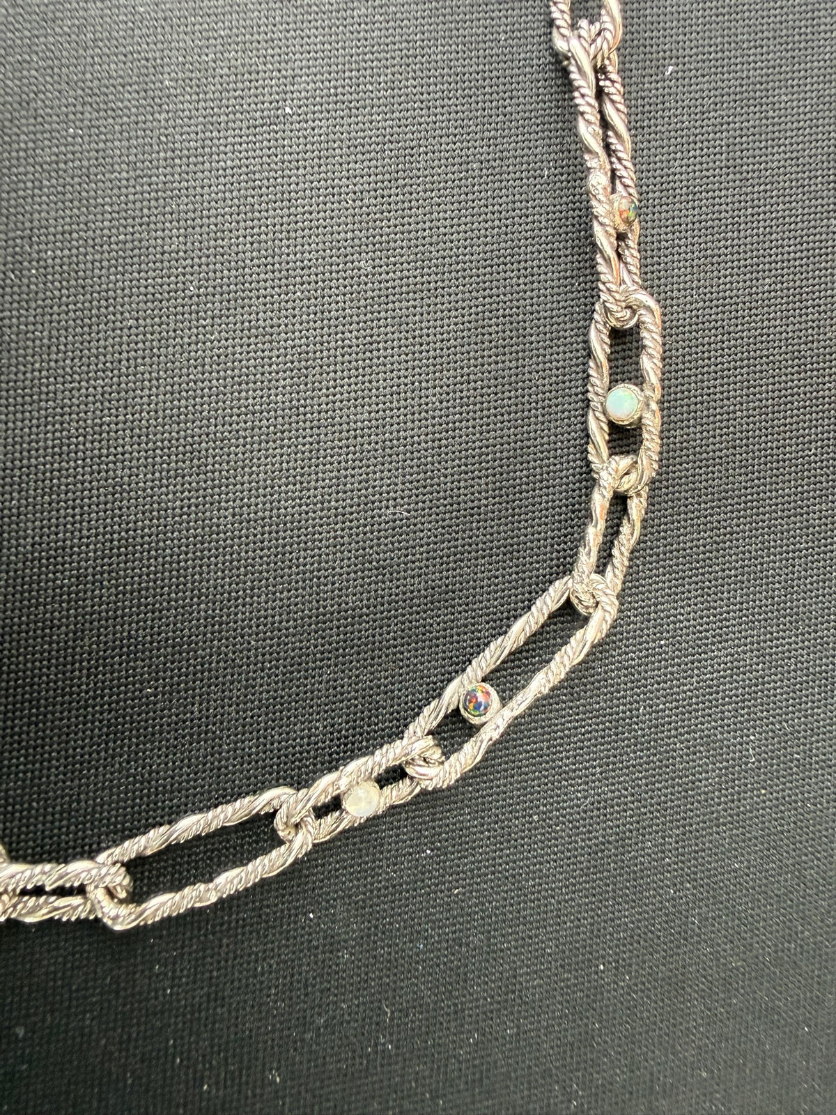 Detail — black opal, white opal, and moonstone cabochons set in the hand-twisted oval links