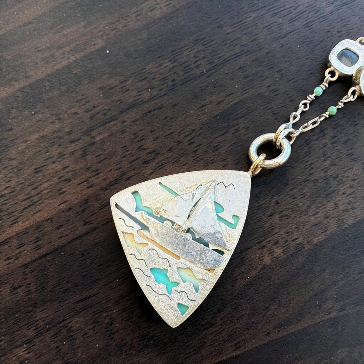 Back of the pendant — pierced sterling sailboat scene with the stone showing through