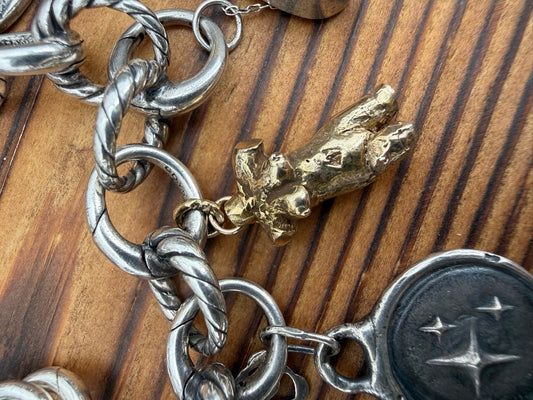 Solid 14k gold female body, lost-wax cast, shown on a charm bracelet